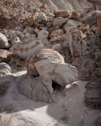 The shadows dance on the jumble of rocks and dry desert plants along the Cockscomb Reef.  This monocline has a series of ridges, called hogbacks, that rise from a rocky base such as this one.